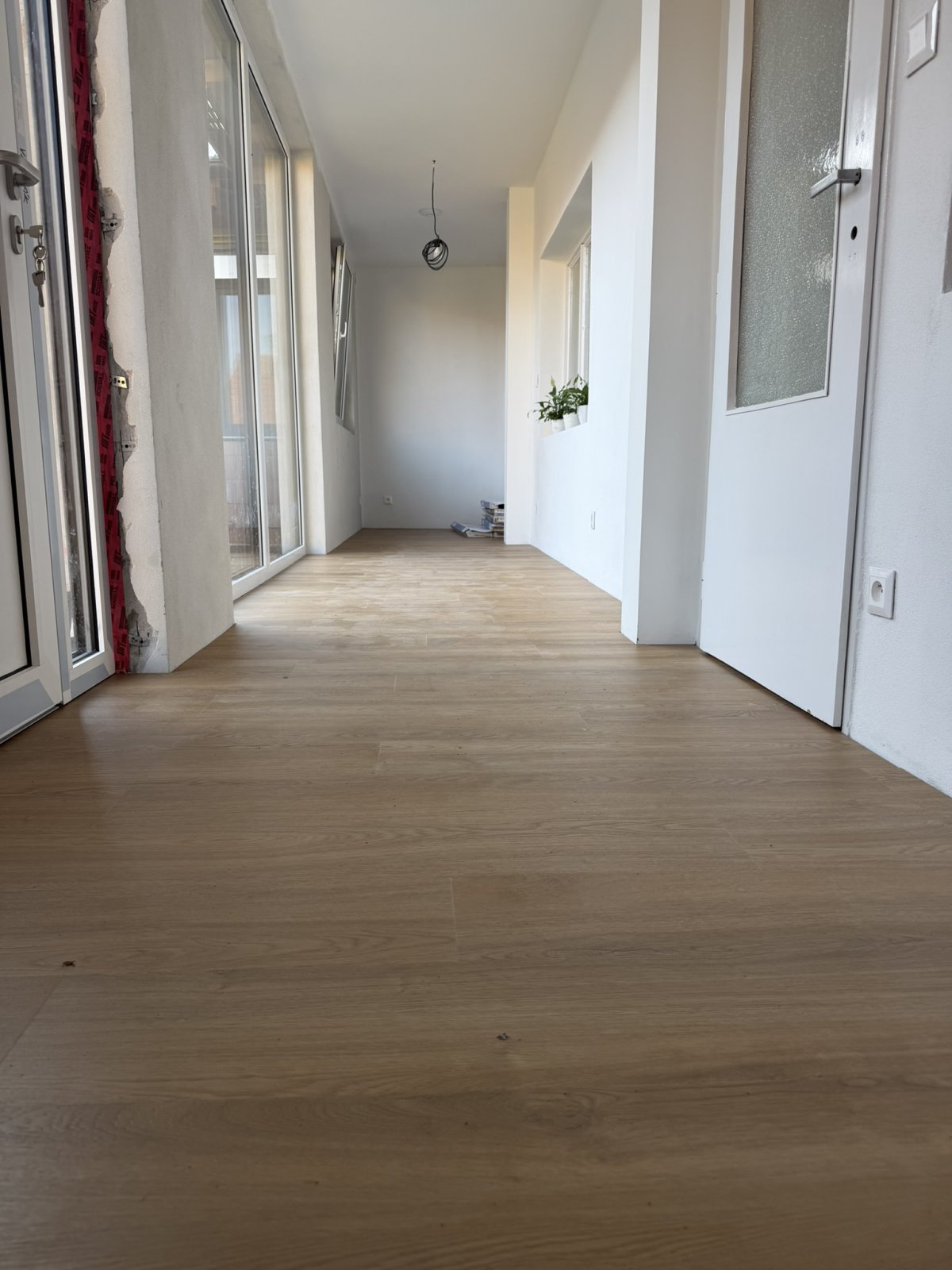 Dokončená lepená vinylová podlaha v dekoru dub královský na verandě, pohled z nízkého úhlu