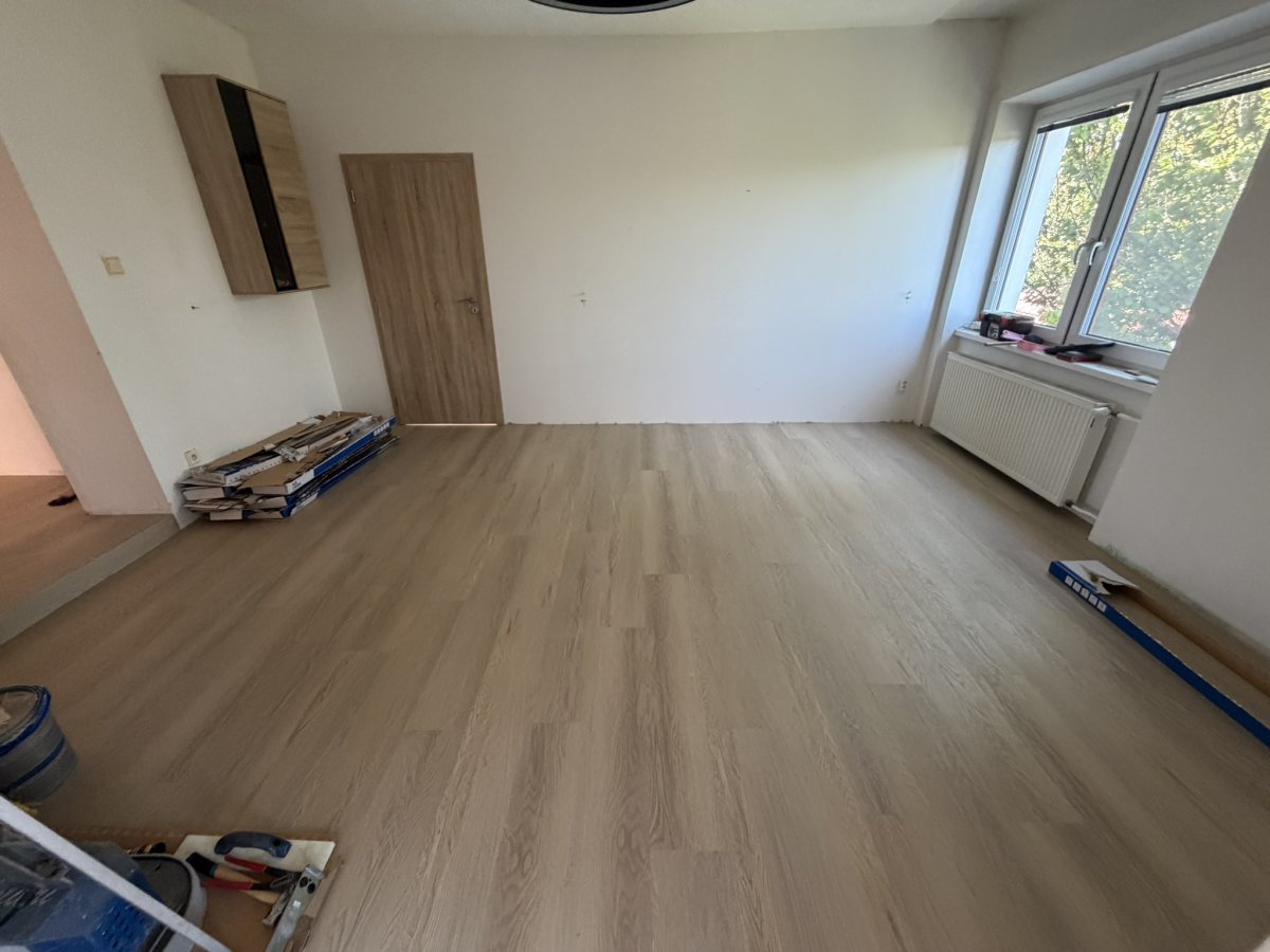 Světlá vinylová podlaha Light Oak v prosvětlené podkrovní ložnici se střešním oknem