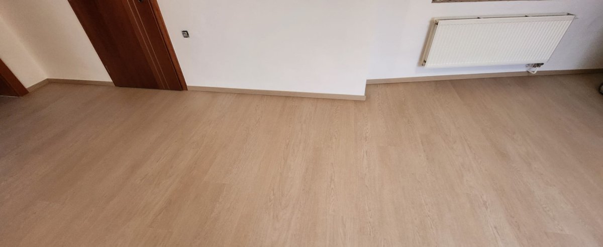 Nová vinylová plovoucí podlaha COREtec v odstínu béžovo-šedá taupe se soklovou lištou