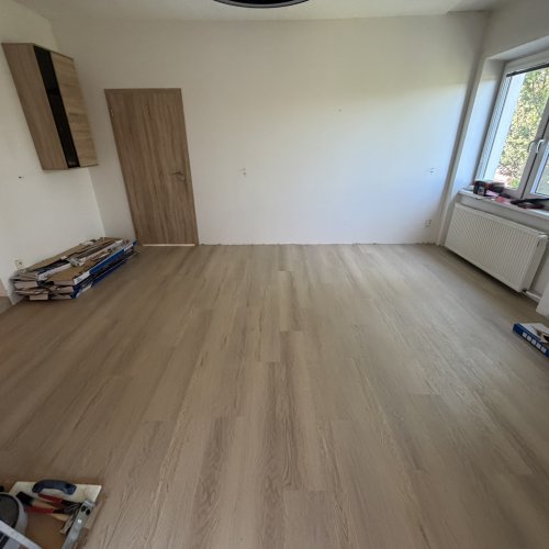 Světlá vinylová podlaha Light Oak v prosvětlené podkrovní ložnici se střešním oknem